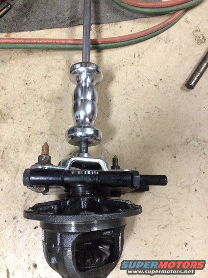 Differential gear assembly with a chrome puller tool attached, on a concrete floor