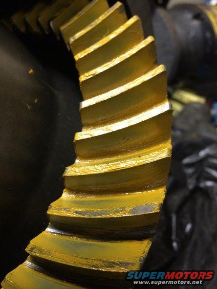 Close-up of a yellow-coated differential ring gear with visible teeth