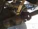 1996 Ford Bronco - Underside view of rear axle and suspension parts, with a blue truck in the distance.