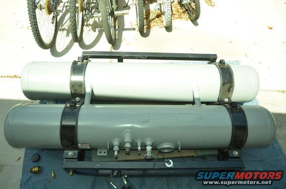 two propane tanks mounted on a rack, bikes in background