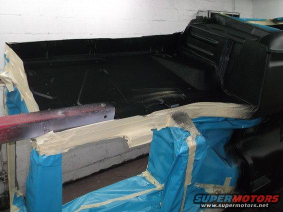 Interior of a car with black paint and masking tape, ready for refinishing