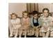 1998 Ford Crown Victoria - A group of four children pose for a photograph while sitting together on a couch.