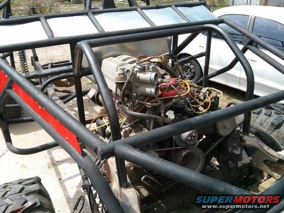 Off-road buggy engine with exposed wiring and belts