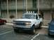 1996 Ford Bronco - White 1996 Ford Bronco with a light bar parked in a lot.