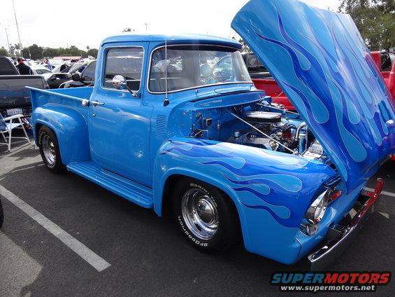 Blue 1956 Ford F-100 pickup truck with flame decals and open hood