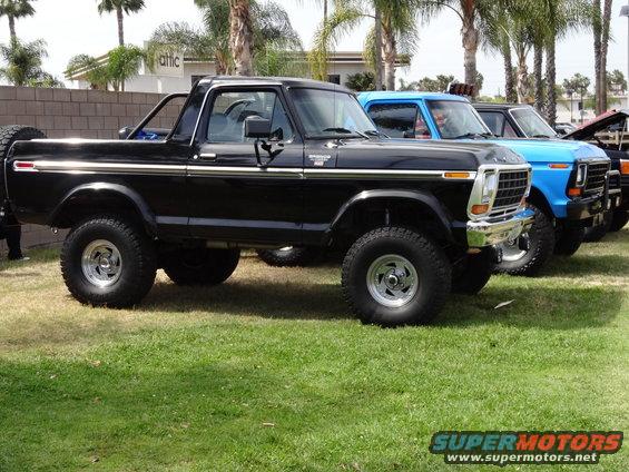 Black Ford Bronco with chrome trim and aftermarket wheels, parked on grass