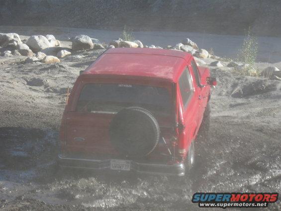 1988 Ford Bronco rear view stuck in mud with spare tire on back