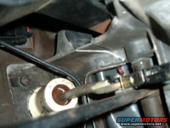 Close-up of vehicle transmission linkage with cables and metal components
