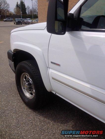 White 2006 Chevrolet Silverado 2500 pickup truck, front quarter view showing fender, wheel, and door trim