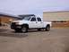 2006 Chevrolet Silverado 2500 - A white Chevrolet Silverado pickup truck is parked in an asphalt lot with a building in the background.