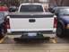 2006 Chevrolet Silverado 2500 - Rear view of a white 2006 Chevrolet Silverado 2500 pickup truck parked between other vehicles.