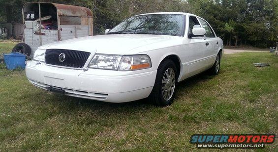 2000 Mercury Grand Marquis LSE sedan parked on grass, front 3/4 view
