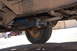 1981 Ford F-250 - Underside view of a vehicle's exhaust system and tire, with another red pickup truck visible in the distance.