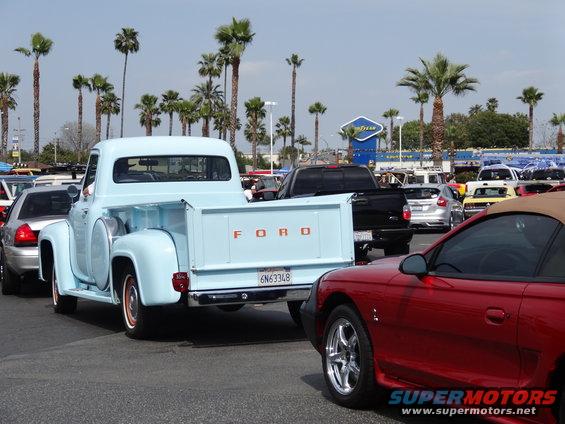 Light blue 1953 Ford F-100 pickup truck with "FORD" on tailgate, parked in lot