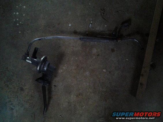 Steering component with metal rod and black housing on a concrete floor