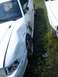 1996 Ford Mustang - A damaged white 1996 Ford Mustang GT is seen from the front passenger side, parked beside another white car.
