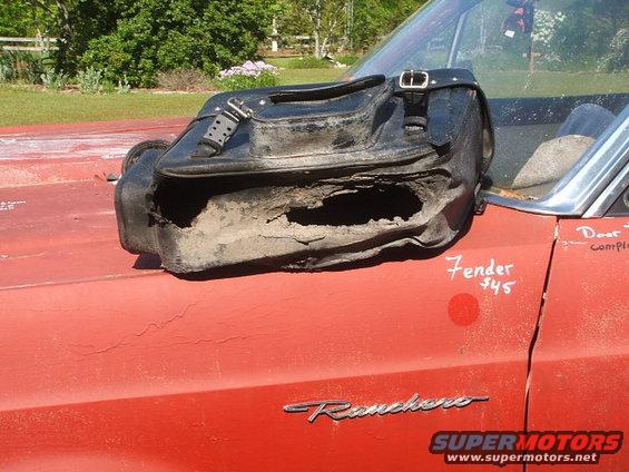 Damaged black leather saddlebag with large holes, resting on the hood of a red car with 'Ranchero' emblem. Text 'Fender $45' is written on the hood