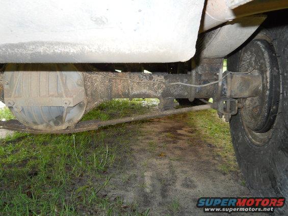 Underside view of a vehicle's rear axle, leaf springs, and tire
