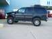 1998 Ford Expedition - This lifted black 1998 Ford Expedition is parked outside a building with a Coca-Cola machine visible.