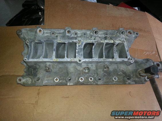 Engine intake manifold with multiple ports. Part is made of metal and appears used