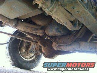 Underside view of vehicle suspension and exhaust system. SuperMotors.net logo visible