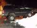 1998 Ford Expedition - A dark blue 1998 Ford Expedition with a lifted suspension navigates a snowy incline at night.