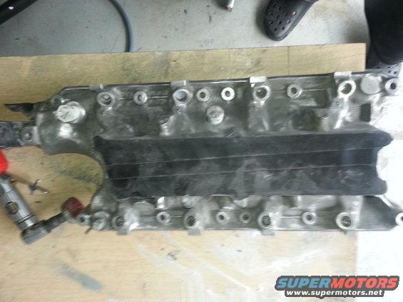 Engine intake manifold on a wooden surface