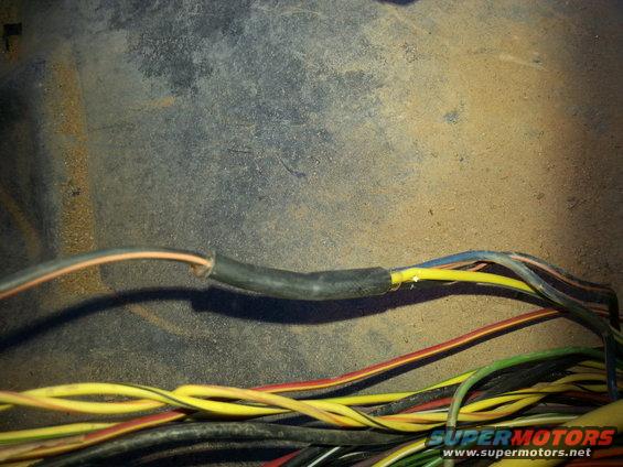 Exposed wires with electrical tape and a bundle of colorful wires