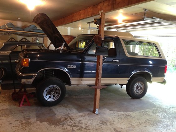 1990 Ford Bronco, dark blue and tan, 3/4 front view with hood open