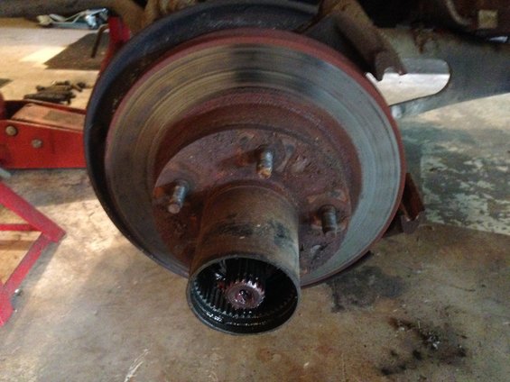 Rusty brake rotor and hub assembly with splined axle shaft visible