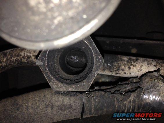 Exhaust pipe fitting with carbon buildup and damaged hose