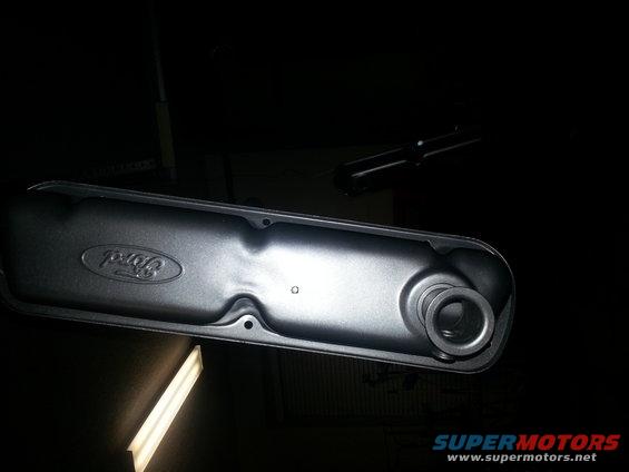 Black Ford valve cover with embossed logo, angled view