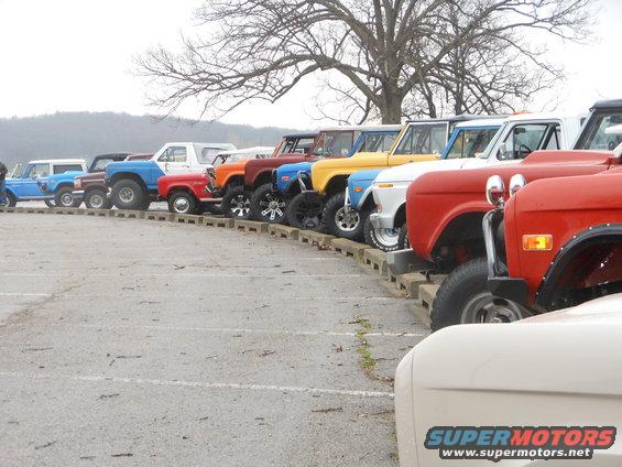 Line of Ford Broncos parked in a lot, mostly older models