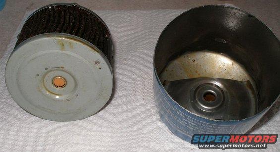 Used oil filter next to its empty canister. The filter element is visible on the left, and the empty metal canister is on the right