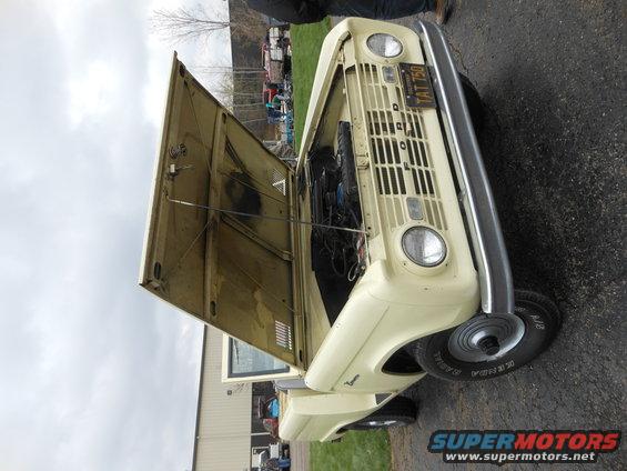 Cream SUV with hood open, showing engine. TAT 750 license plate