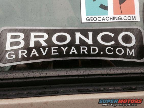 Black sticker with white text 'BRONCO GRAVEYARD.COM' on a vehicle window
