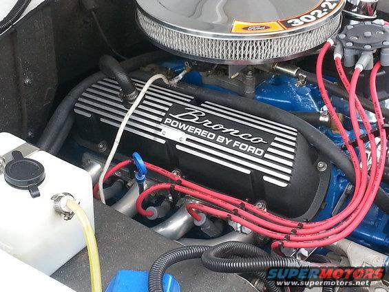 Ford Bronco engine valve cover with "Powered by Ford" text, chrome air cleaner, red spark plug wires