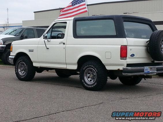 White 1995 Ford Bronco with American flag, side view