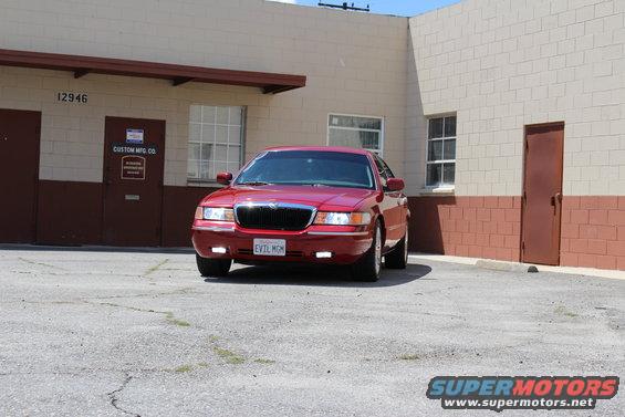 Red 2002 Mercury Grand Marquis parked in front of a building