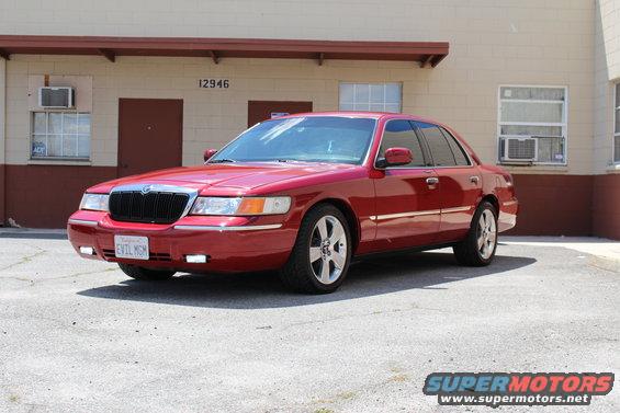 Red 2002 Mercury Grand Marquis parked outside a building