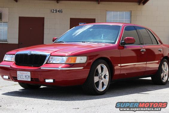 Red 2002 Mercury Grand Marquis sedan, front 3/4 view. License plate reads 'EVIL MGM'