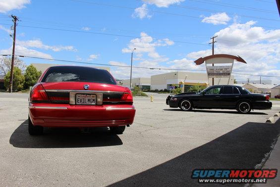 Red Mercury Grand Marquis rear view, license plate reads EVIL MGM
