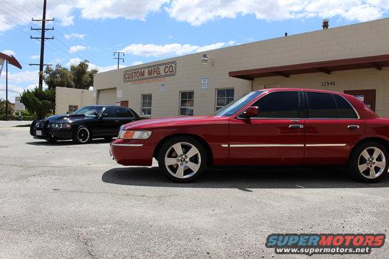 Red 2002 Mercury Grand Marquis side view, parked next to black sedan