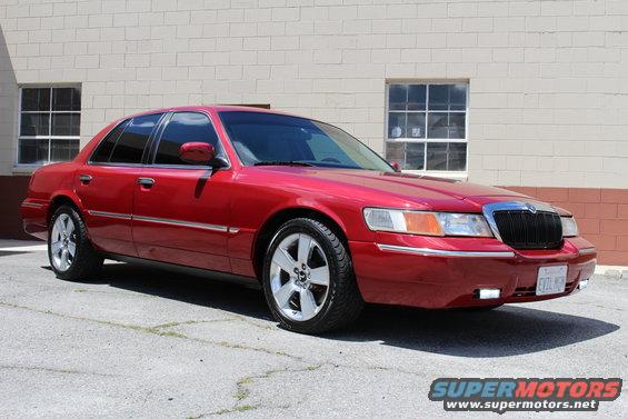 Red 2002 Mercury Grand Marquis parked outside. Front grille and headlights visible