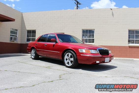 Red 2002 Mercury Grand Marquis parked in a lot. Front quarter view