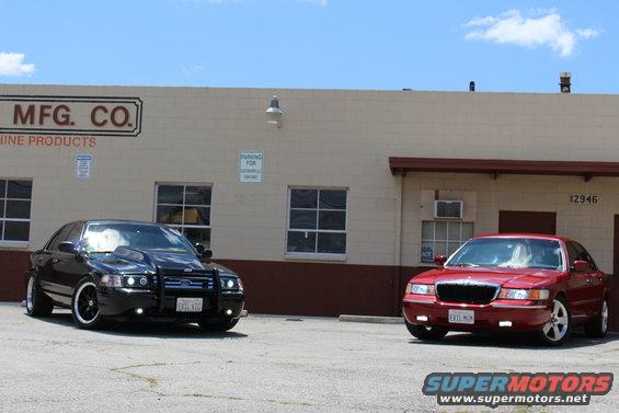 Red 2002 Mercury Grand Marquis parked next to a black sedan