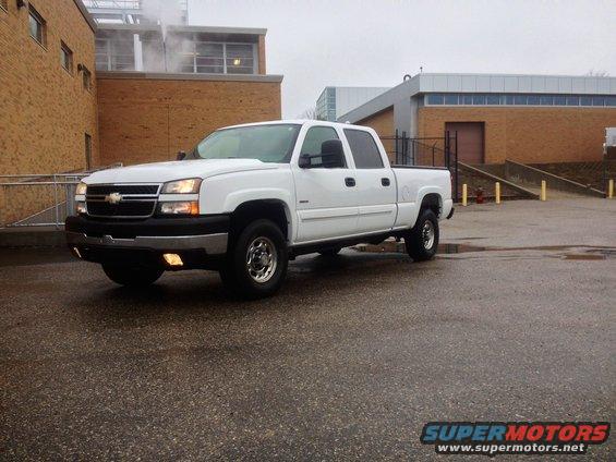 White 2006 Chevrolet Silverado 2500 pickup truck parked outside a brick building