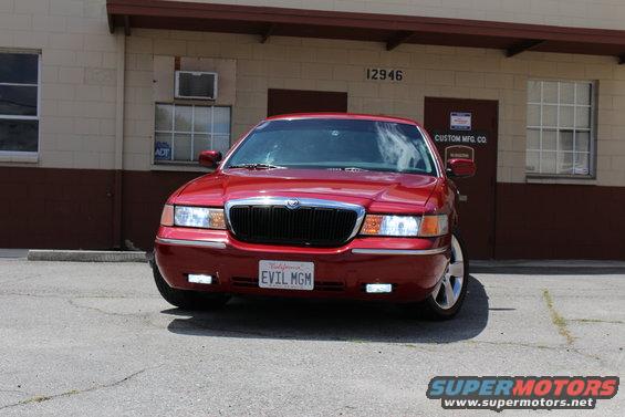 Red 2002 Mercury Grand Marquis front view with custom license plate "EVIL MGM"