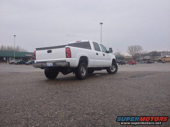 White crew cab pickup truck parked in a lot. License plate reads 'DCT 200'