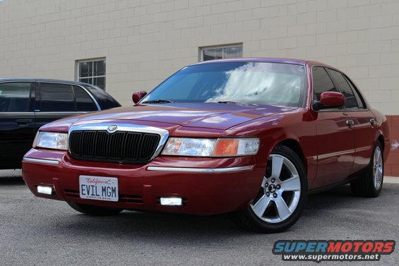 Red 2002 Mercury Grand Marquis parked outside, black car behind it